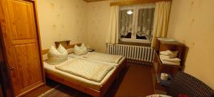 a small bedroom with two beds and a window at Pension Harzresidenz in Thale +30 photos