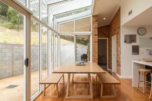 a dining room with a wooden table and glass doors at House on the Hillside with City Views Sleeps 12 in Howrah