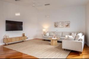 a living room with a couch and a table at House on the Hillside with City Views Sleeps 12 in Howrah