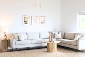a living room with a white couch and a table at House on the Hillside with City Views Sleeps 12 in Howrah