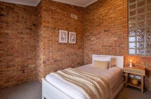 a bedroom with a brick wall with a bed in it at House on the Hillside with City Views Sleeps 12 in Howrah