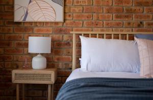 a bedroom with a bed and a brick wall at House on the Hillside with City Views Sleeps 12 in Howrah