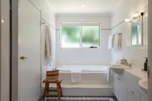 a white bathroom with a tub and a sink at House on the Hillside with City Views Sleeps 12 in Howrah