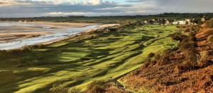 an aerial view of a golf course next to the beach at Alnmouth Glamping in Alnmouth