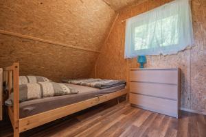 a bedroom with a bed and a window at Chatki Szymonówko in Liksajny