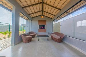 a lobby with chairs and a table and windows at Espaço premium, Casa com 5 quartos, piscina aquecida & Jacuzzi in Caldas Novas