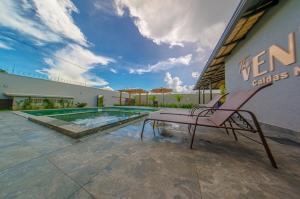 a chair sitting on a patio next to a swimming pool at Espaço premium, Casa com 5 quartos, piscina aquecida & Jacuzzi in Caldas Novas