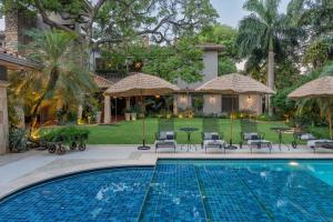 a swimming pool with chairs and umbrellas next to a house at Casa Corbellani in Asunción
