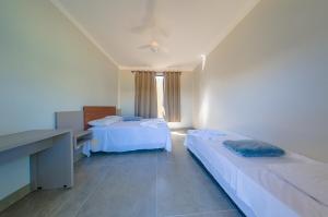 a hotel room with two beds and a desk and a desk at Espaço premium, Casa com 5 quartos, piscina aquecida & Jacuzzi in Caldas Novas +29 photos
