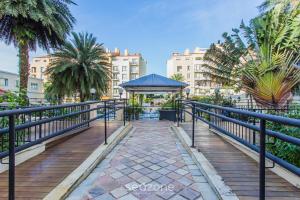 a boardwalk with a gazebo and palm trees and buildings at Coberturas sofisticadas no IL Campanario Resort ILCTOPM in Florianópolis