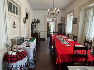 a dining room with two long tables with red tablecloths at Vitorina Corte Guesthouse in Funchal