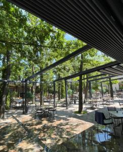 a patio with tables and chairs and trees at Hotel Europa 92 in Ferizaj