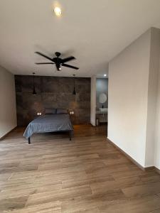 a bedroom with a bed and a ceiling fan at La Gran Manzana in Tizimín