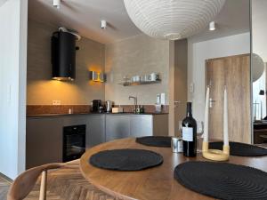 een keuken met een houten tafel en een fles wijn bij Widok Marzeń Sun&Ski Romantic Art House z garażem in Krynica Zdrój +68 foto's