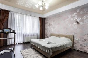 a bedroom with a bed with flowers on the wall at Spacious apartment with terrace in Chişinău