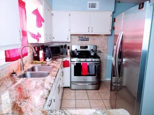 a kitchen with white cabinets and a stainless steel refrigerator at Charles Stays in Kansas City