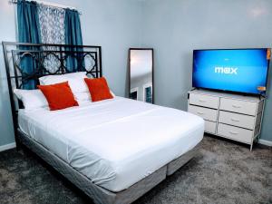 a bedroom with a bed and a television on a dresser at Charles Stays in Kansas City
