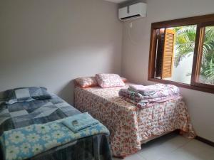 a small room with two beds and a window at Hospedagem Sil e Jean quarto triplo, cozinha compartilhada com outros hóspedes in São Gabriel