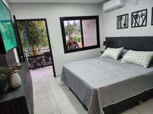 维拉卡洛斯帕兹Hotel El Paraiso Boutique的一位妇女站在卧室里,卧室里配有床 更多37张照片