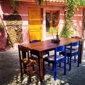 a wooden table and chairs in front of a house at -Giardino- Vakantiehuis tussen de olijvenbomen in Donori