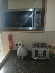 encimera de cocina con tostadora y microondas en Caravan on Lyons winkups holiday park, en Kinmel Bay 6 fotos más