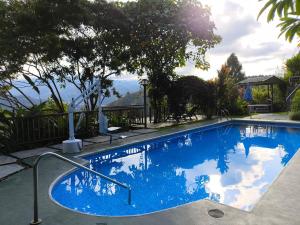 a blue swimming pool with a view of the ocean at El Ensueño in Ujarrás