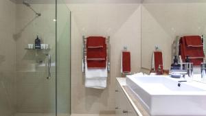une salle de bain avec un lavabo et une douche en verre dans l'établissement The Palms at Byron, à Byron Bay 11 autres photos