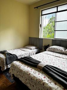 three beds in a room with a window at Casa JK Exclusiva Centro Diamantina in Diamantina +27 photos
