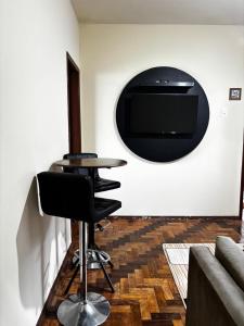 a room with three chairs and a table and a tv at Casa JK Exclusiva Centro Diamantina in Diamantina