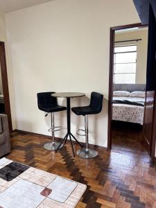 a room with a table and two chairs and a bed at Casa JK Exclusiva Centro Diamantina in Diamantina
