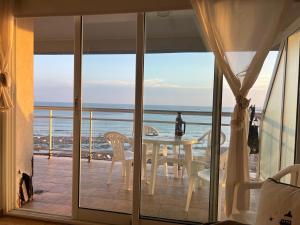 a table and chairs on a balcony with a view of the ocean at Monte Hermoso frente al mar in Monte Hermoso