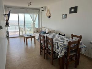 a dining room with a table and a view of the ocean at Monte Hermoso frente al mar in Monte Hermoso