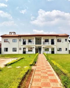 a large white building with a grass yard at Luma in Yaoundé