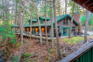 米尔福德Couple's Retreat Lodge with Hot Tub and River Views的树林中间的木屋