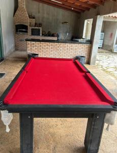 un tavolo da ping pong rosso davanti a una griglia di Rancho Rallf a Santo Antônio do Descoberto