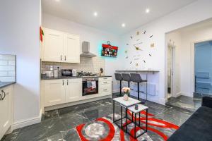 a kitchen with white cabinets and a red rug at -75ACR- Setup for your relaxed & amazing stay in Leeds