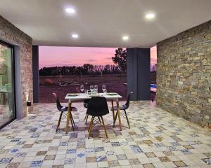 a dining room with a table and chairs on a tile floor at Elysium de Uco in Tupungato