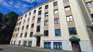 a large white building with windows on a street at Bright 2-BDRM central apartment in Tallinn
