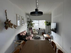 una sala de estar con una mesa y un sofá en 伊勢志摩観光に最適 パールロードの玄関口 PAARU inn 2階B室 セルフチェックイン, en Toba