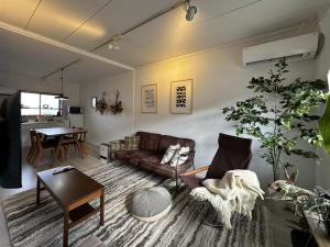 una sala de estar con un sofá y una mesa en 伊勢志摩観光に最適 パールロードの玄関口 PAARU inn 2階B室 セルフチェックイン, en Toba
