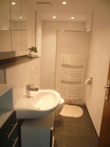 a white bathroom with a sink and a toilet at Ferienwohnung Ruhrtalblick in Bestwig