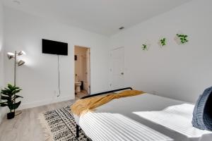 a white bedroom with a bed and a flat screen tv at 3 Mi to Six Flags Apartment in Metro Atlanta in Mableton
