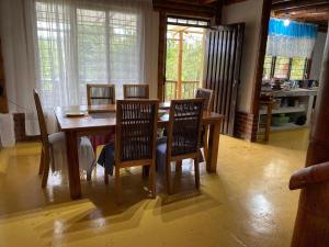 a dining room with a wooden table and chairs at casa bambuza in La Cumbre