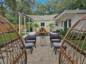 a patio with chairs and a table in a backyard at -Disco Bungalow- One third mile to FTL Marine Center in Fort Lauderdale +35 photos