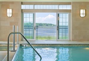 uma piscina no átrio do hotel com uma grande janela em Newport Beach Hotel & Suites em Middletown