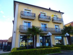 ein Gebäude mit Balkonen und Palmen davor in der Unterkunft Albergo Sirena in Bazzano Bologna