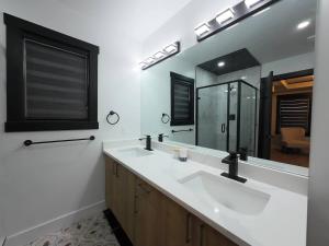 a bathroom with two sinks and a large mirror at The Luxe Escape Calgary I 3BR Vacation Home in Calgary +18 photos