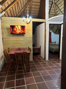 a room with a table and a fireplace on a wall at Cabañas Beija Flor Cabaña Nr 11 in Punta Del Diablo