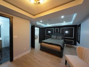 a bedroom with a bed and a couch in a room at The Luxe Escape Calgary I 3BR Vacation Home in Calgary