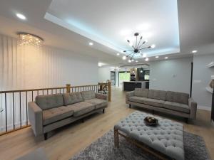 a living room with two couches and a table at The Luxe Escape Calgary I 3BR Vacation Home in Calgary